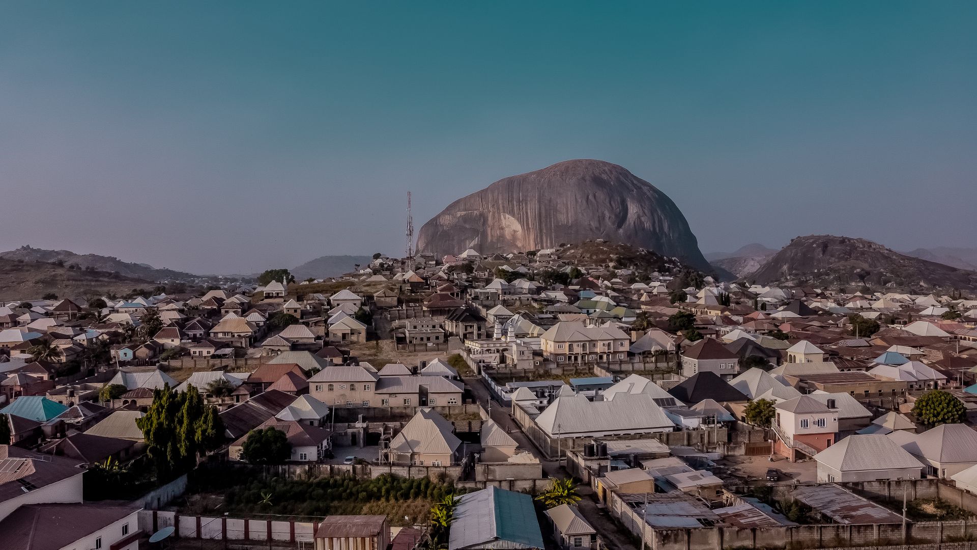 Aerial view of Zuma Rock rising above residential housing near Abuja