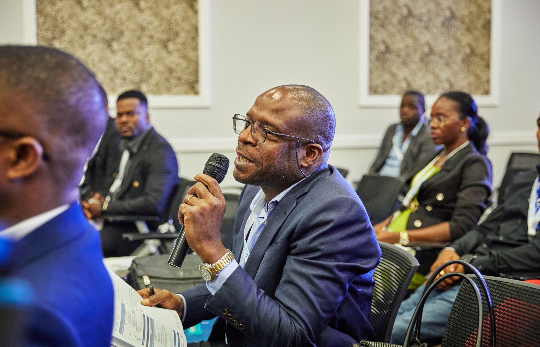 A delegate in a suit putting a question to the panel at a NIFIAN industry session