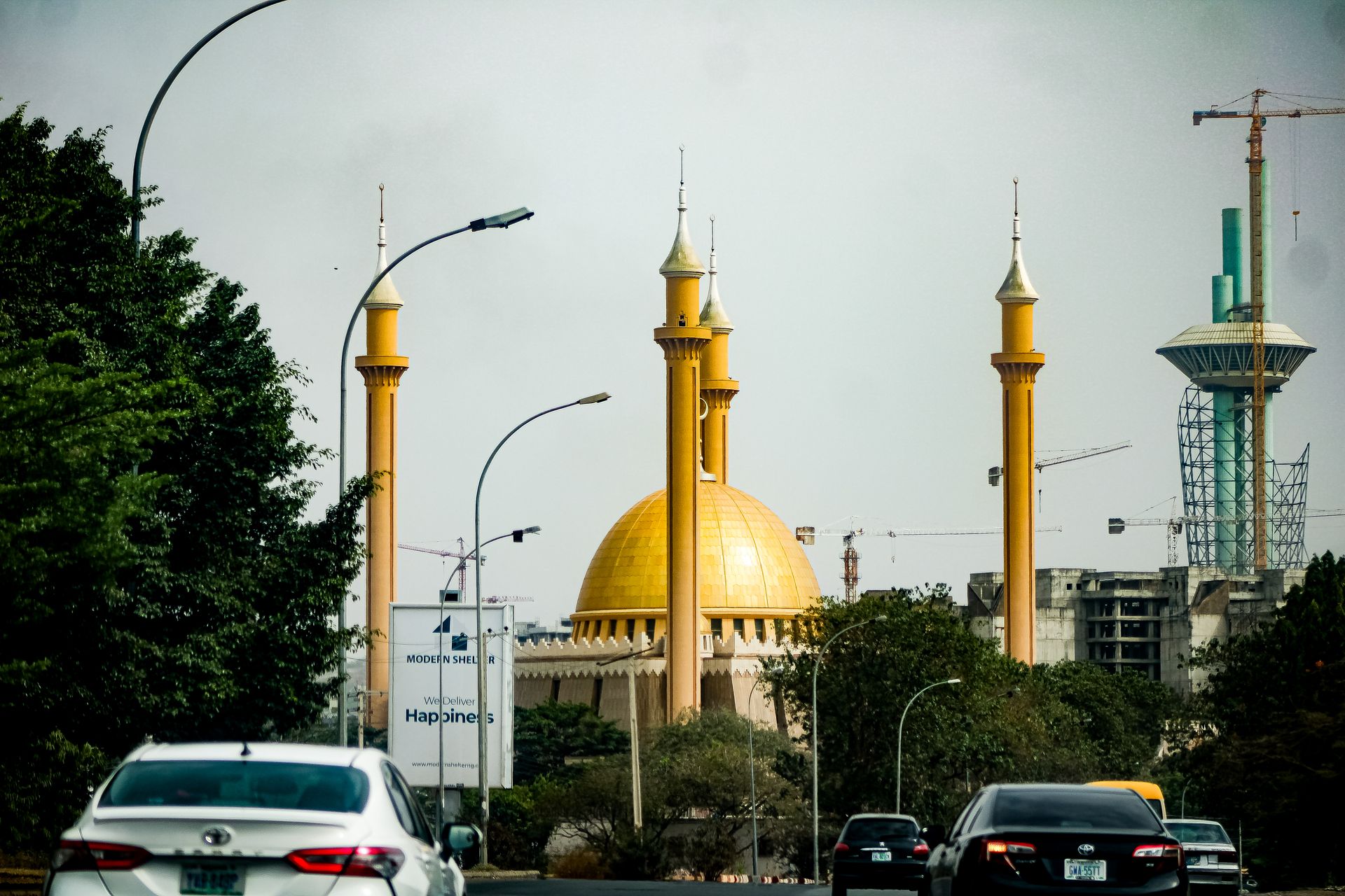 A street in Abuja with the National Mosque's golden dome rising behind the traffic