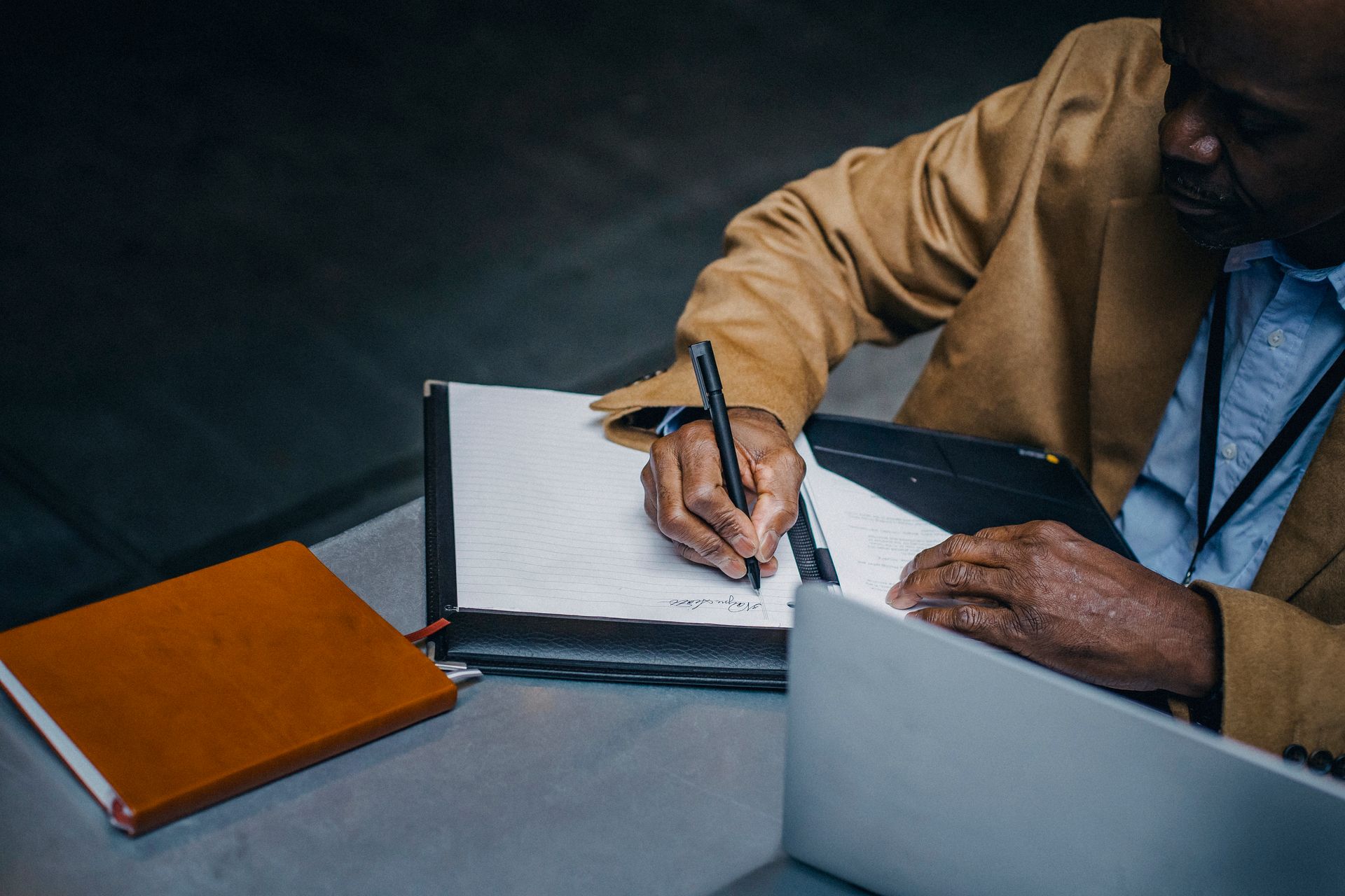 An executive writing notes at a desk