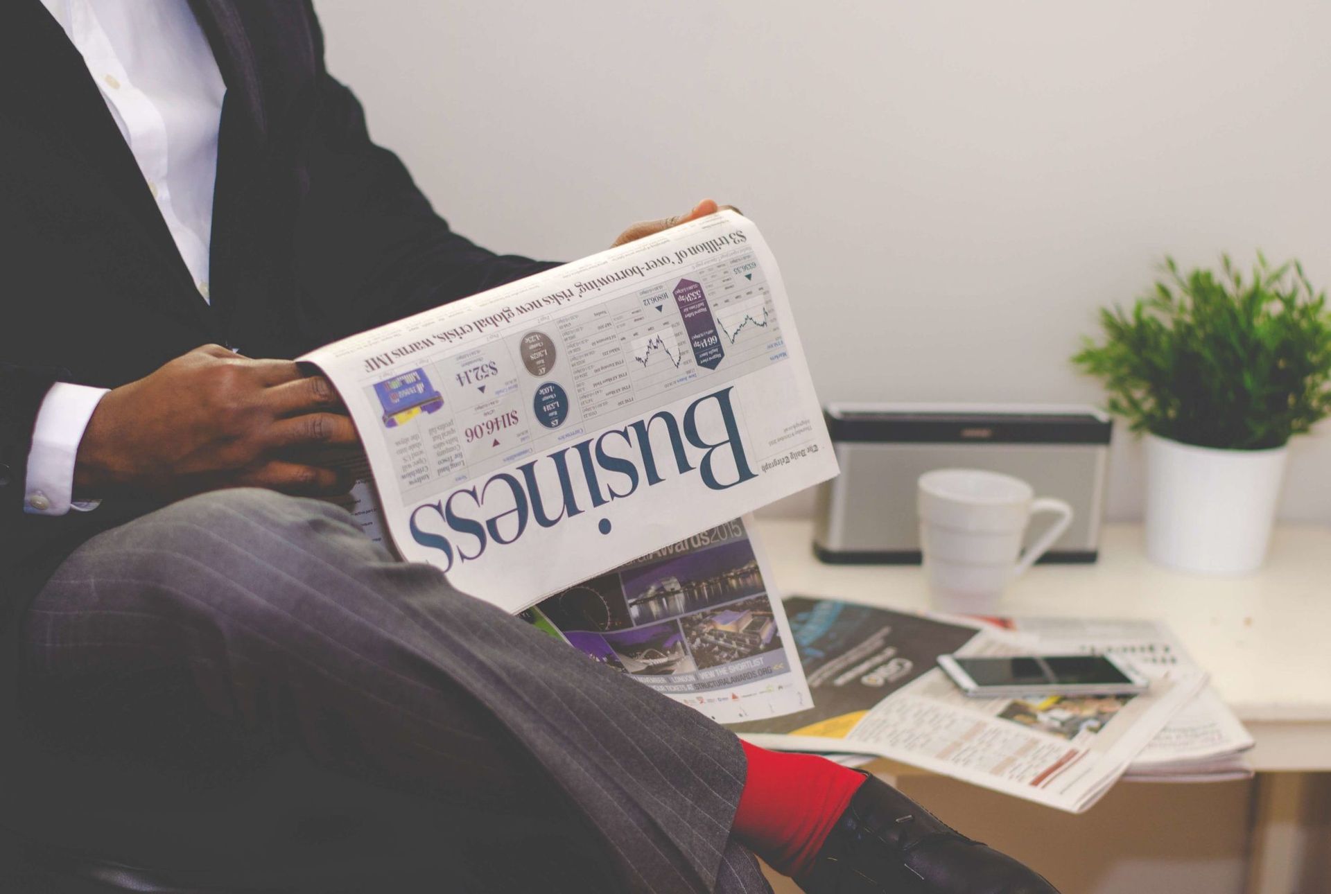 A businessman reading a financial newspaper at a desk